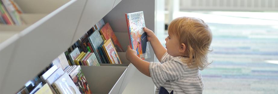 Child picking out a library book